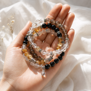 Hand holding clear quartz citrine onyx and crystal energy bracelet set